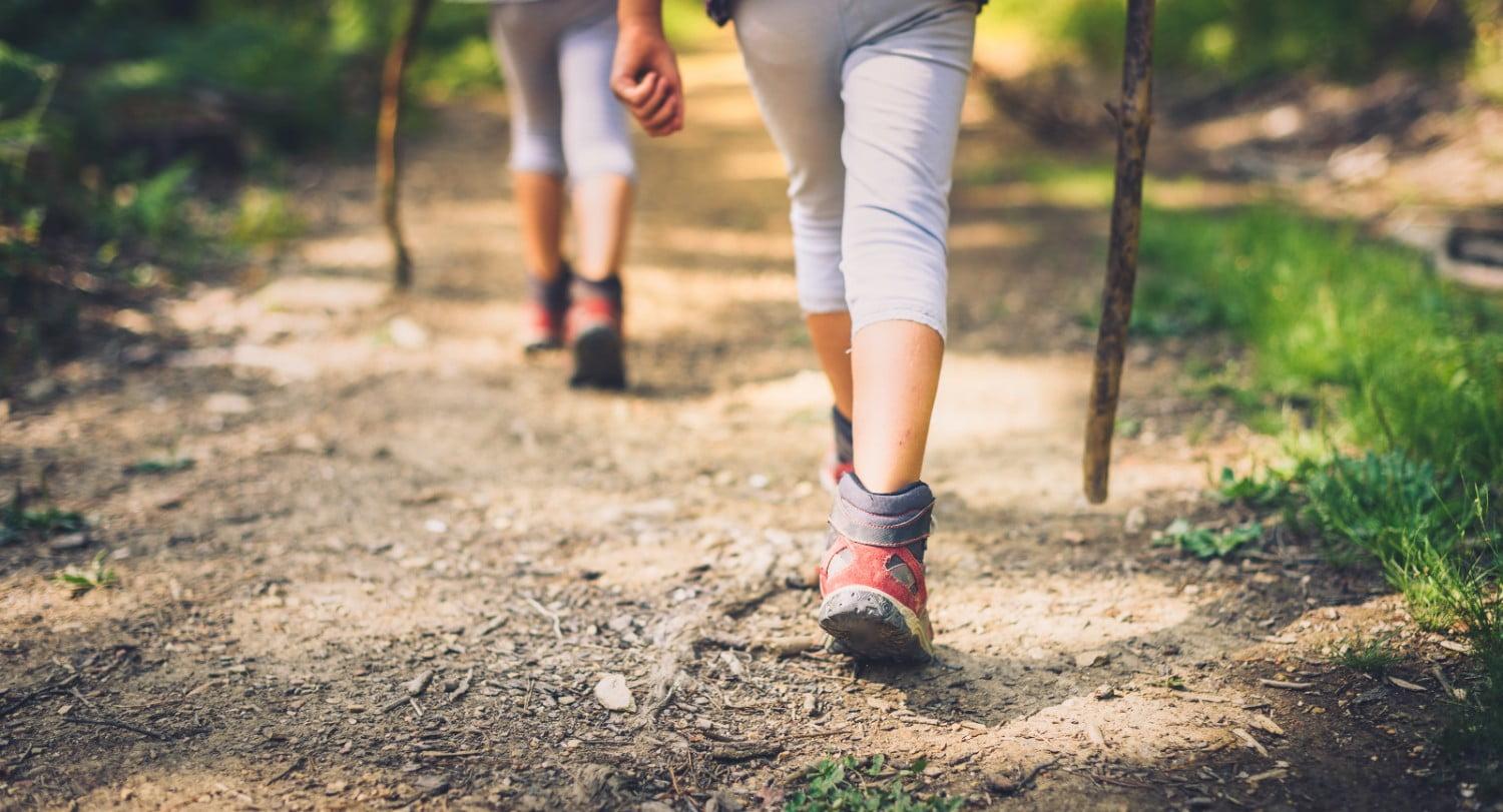 people hiking on trail with hiking sticks