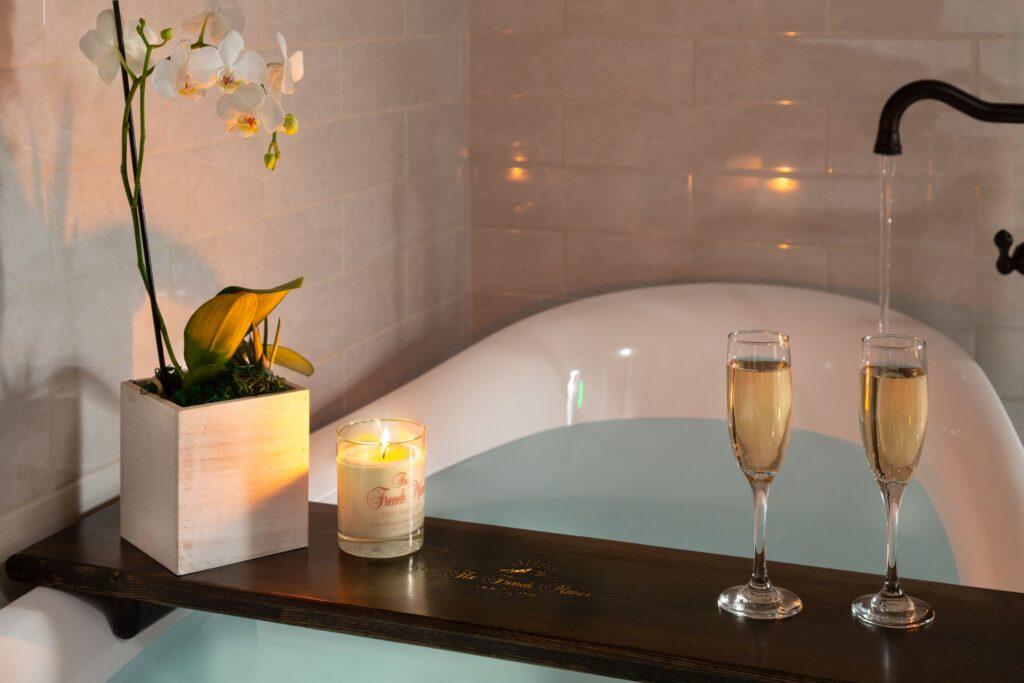 Filled soaking tub with tray holding glass of sparkling wine