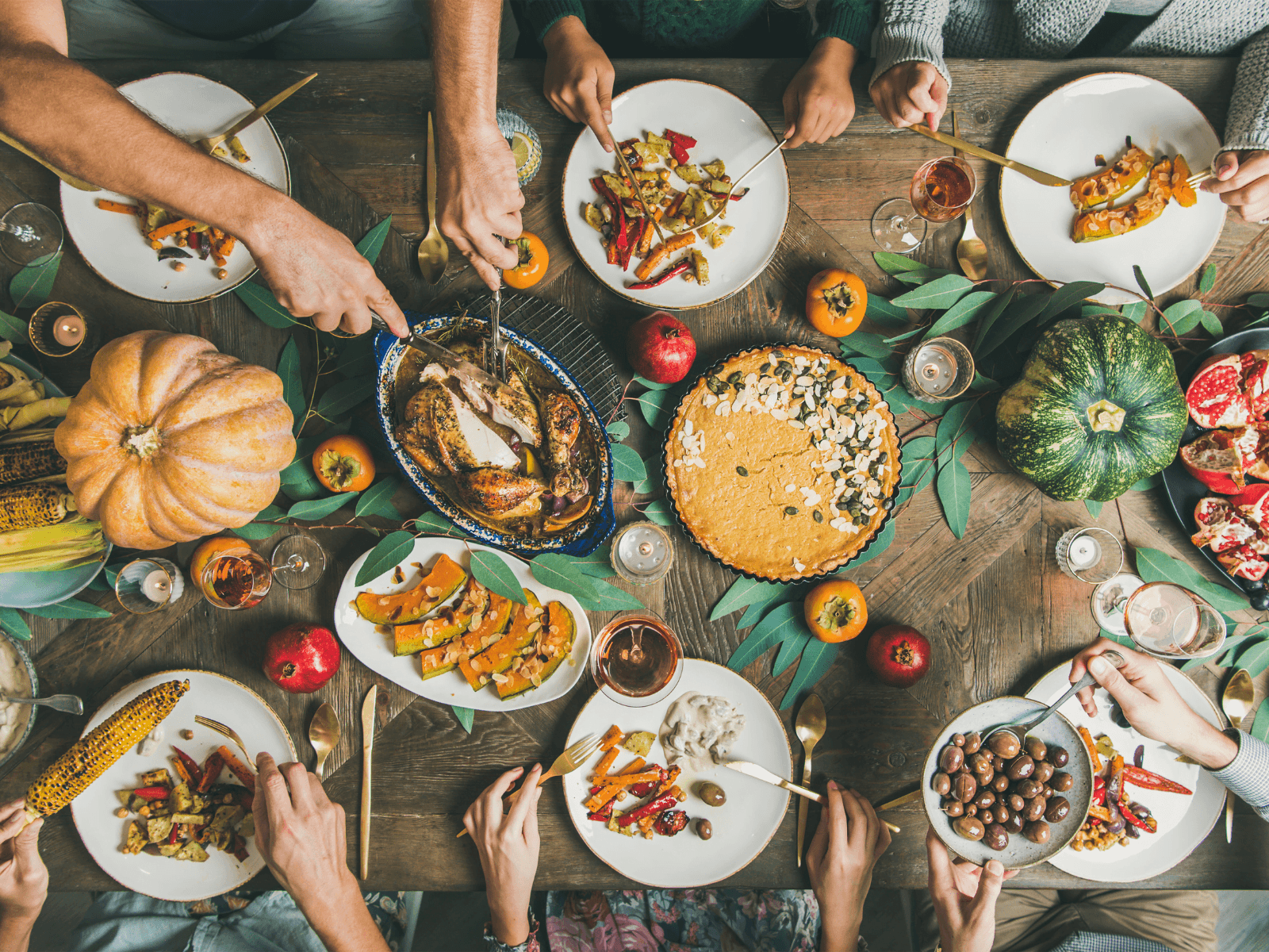 A festive table filled with autumn dishes, garnished with seasonal vegetables and surrounded by people sharing a meal. A festive table filled with autumn dishes, garnished with seasonal vegetables and surrounded by people sharing a meal.