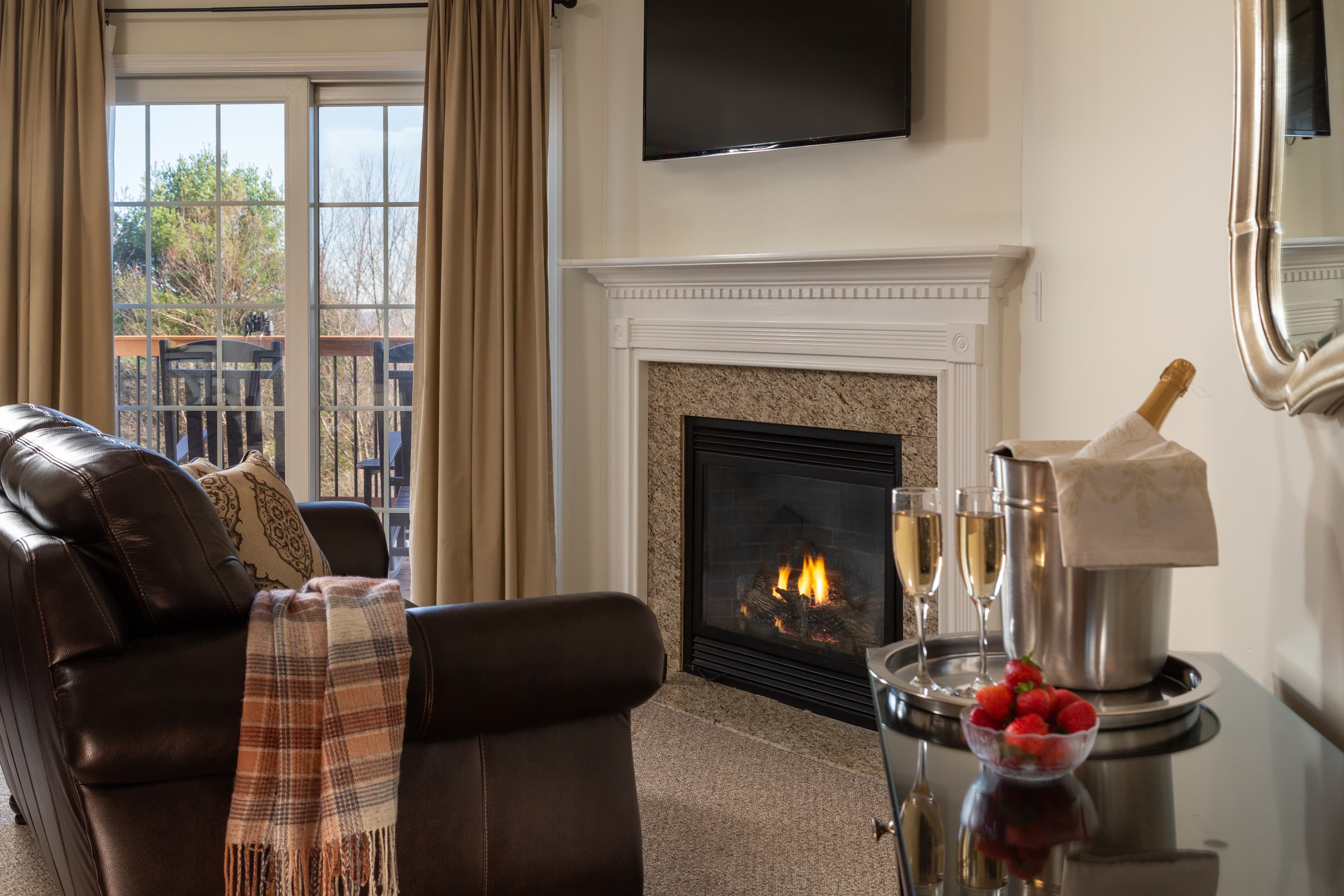 Cozy living room featuring a leather sofa, fireplace, and a view of the outdoors.