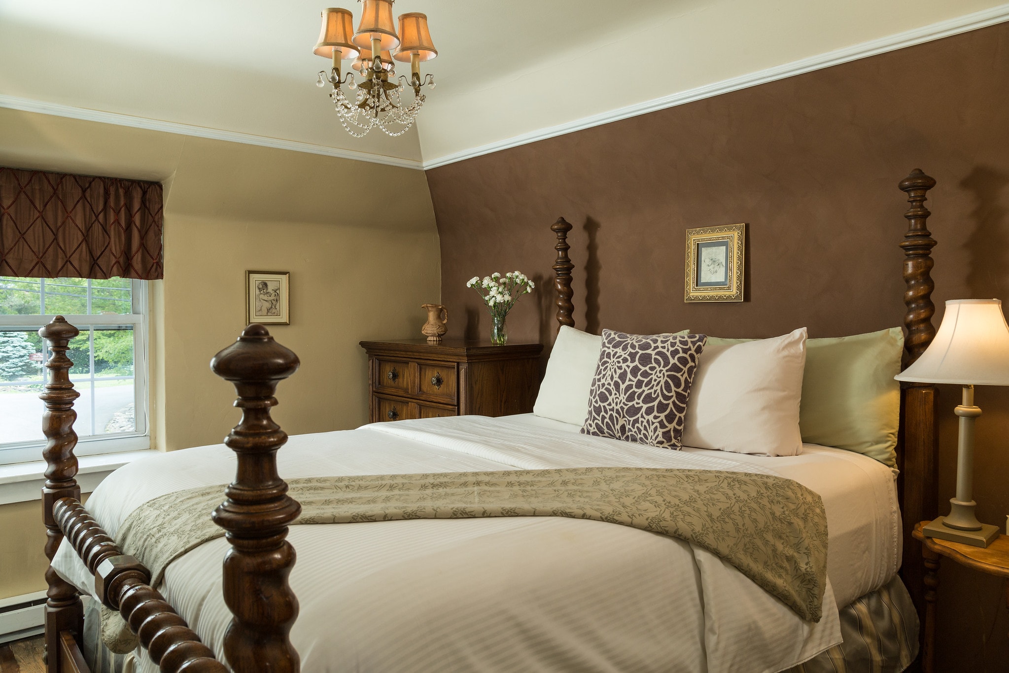 Cozy bedroom featuring a wooden bed, soft linens, and warm lighting.