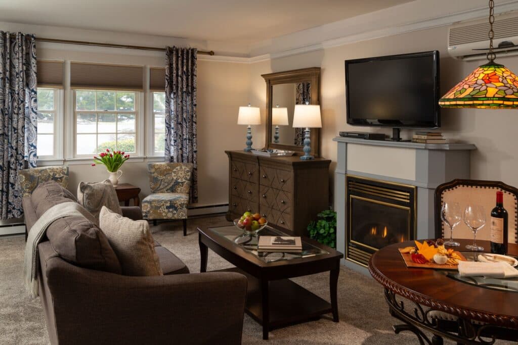 Cozy living room with a fireplace, TV, and elegantly decorated furniture.
