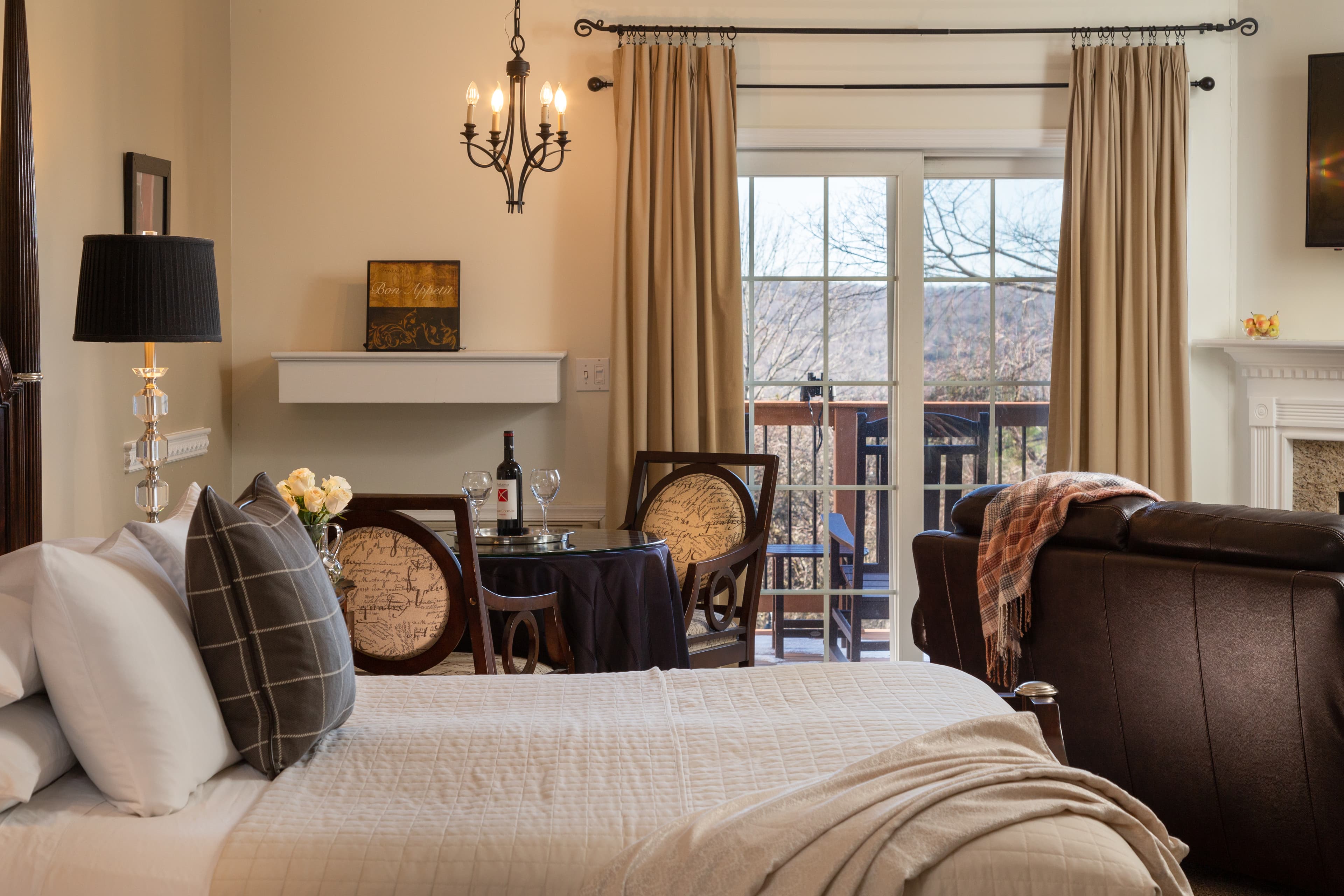 Cozy bedroom featuring a bed, dining area, and balcony doors with a view.