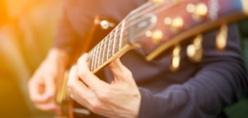 A close-up of a person's hand playing an electric guitar.