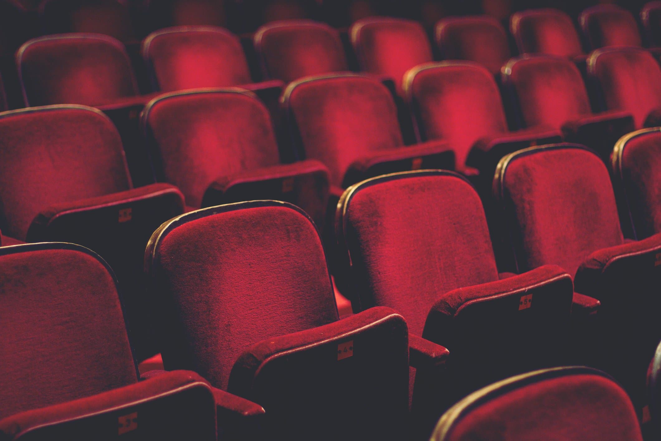 Row of red velvet theater seats.