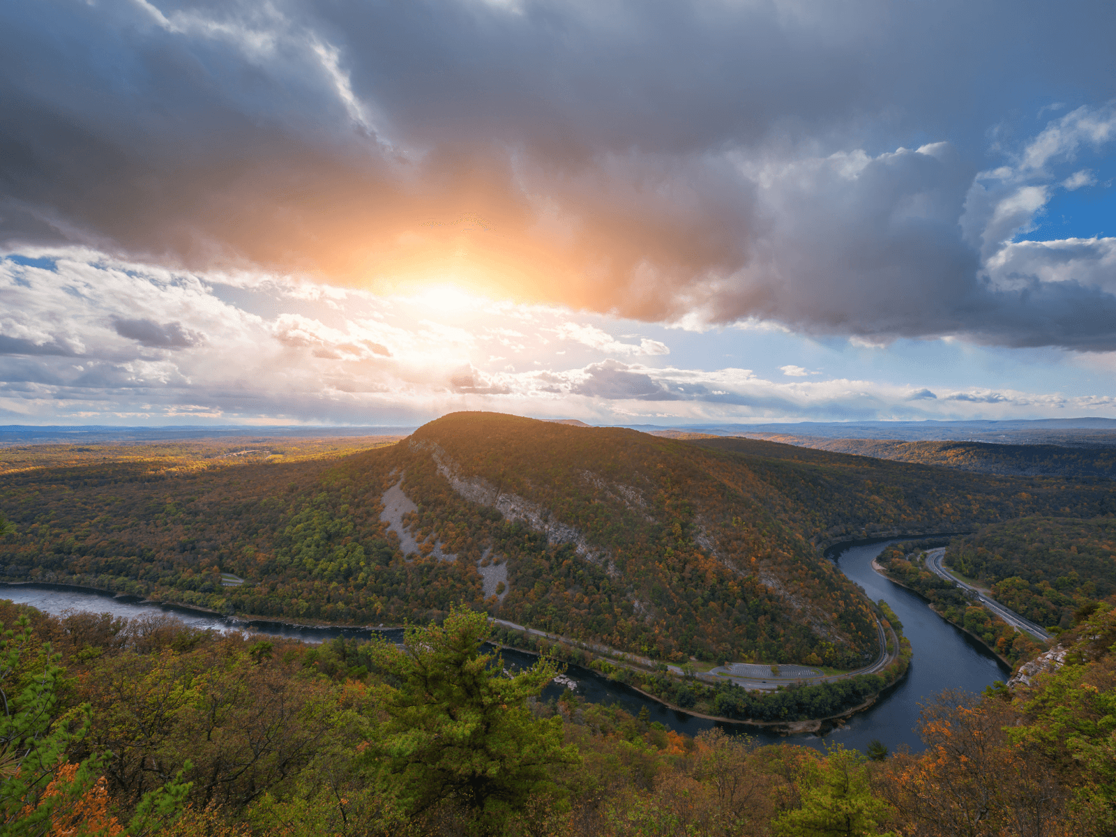 A panoramic view of a vibrant, sunlit landscape featuring rolling hills and a winding river beneath a cloudy sky. A panoramic view of a vibrant, sunlit landscape featuring rolling hills and a winding river beneath a cloudy sky.