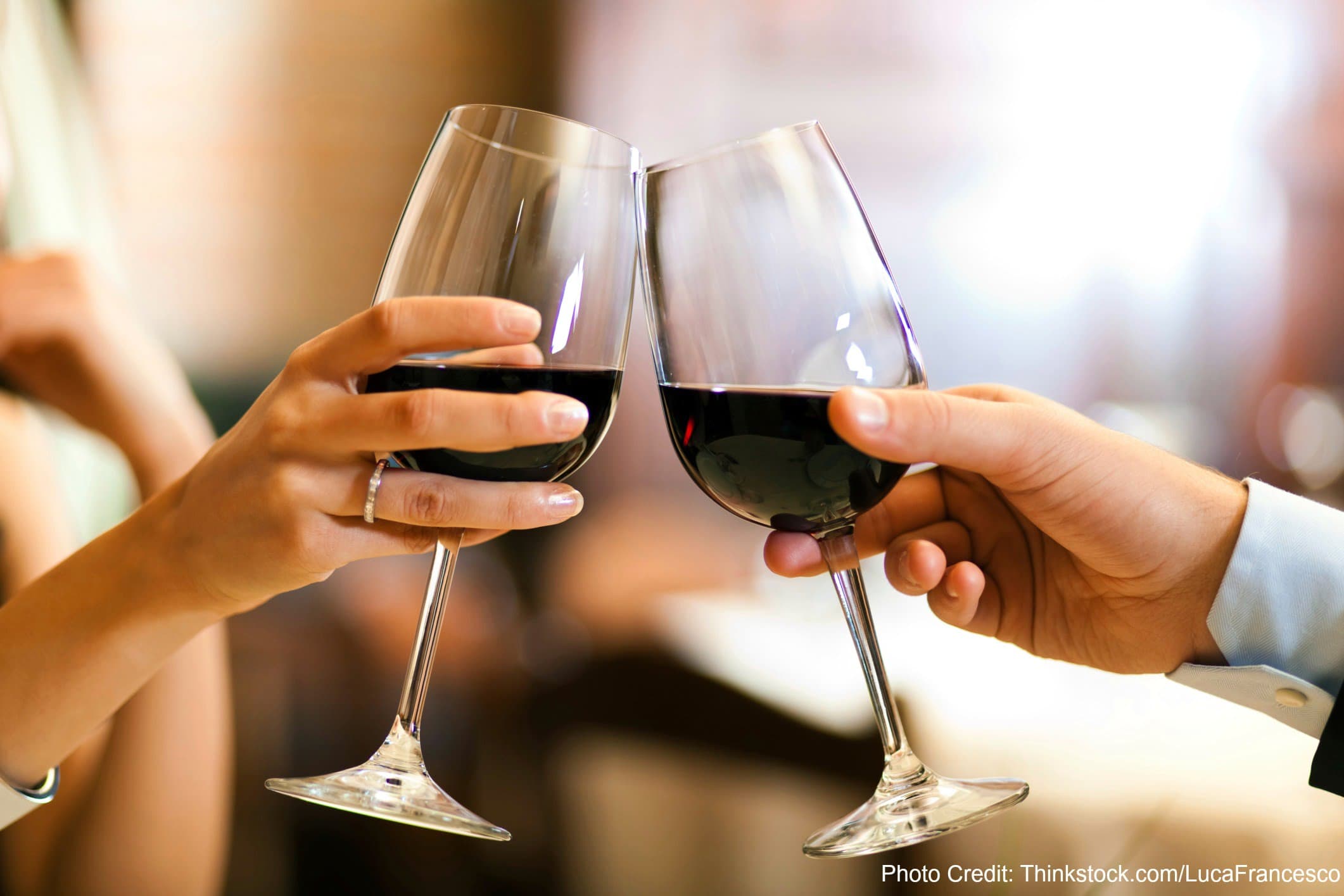 Two hands holding wine glasses, toasting with red wine. Two hands holding wine glasses, toasting with red wine.