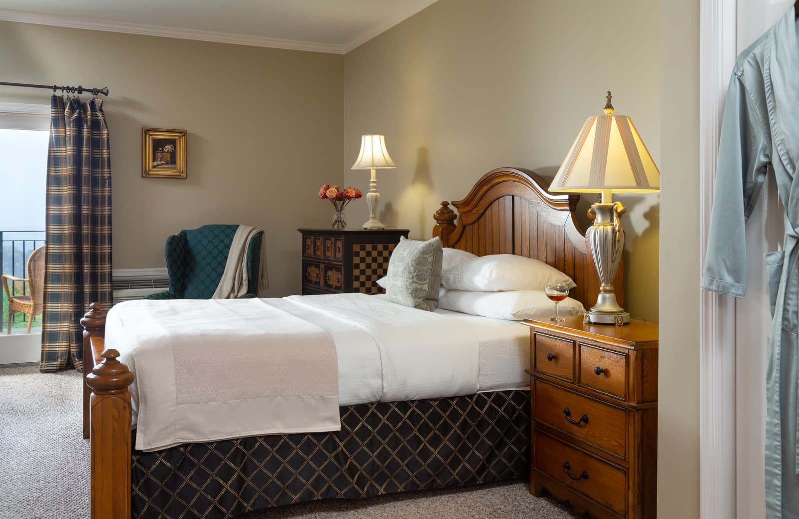 A cozy bedroom featuring a wooden bed, bedside lamps, and a chair by the window.