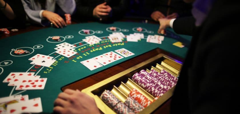A close-up of a poker table with scattered playing cards and stacked chips.