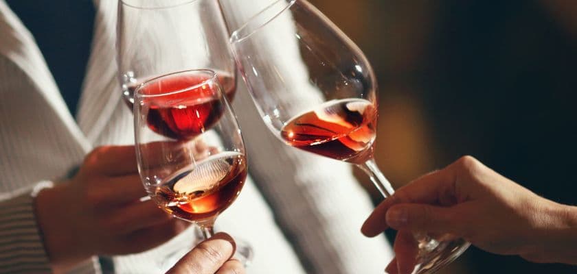 Three people clinking glasses of rose wine